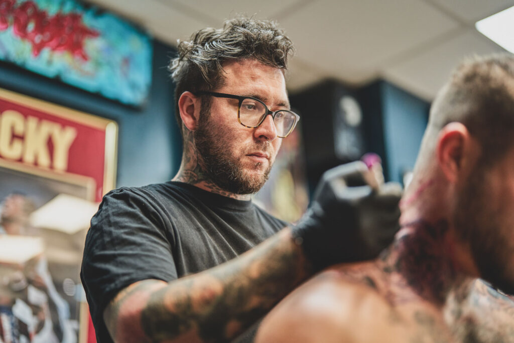 Iggy, Tattoo Artist working in the tattoo studio at Black Dagger Tattoo Norwich - Commercial Photography Lee Blanchflower