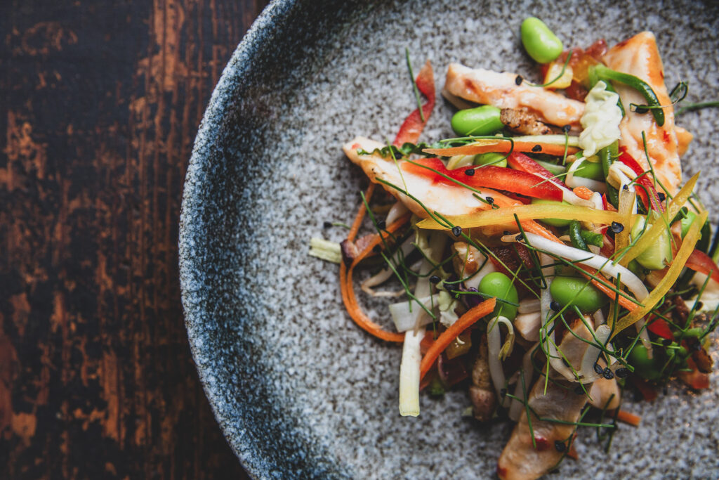 A naturally lit plate of Stir Fried Food on a wooden table - 5 Amazing Food Photography Tips by Blanc Creative Norwich