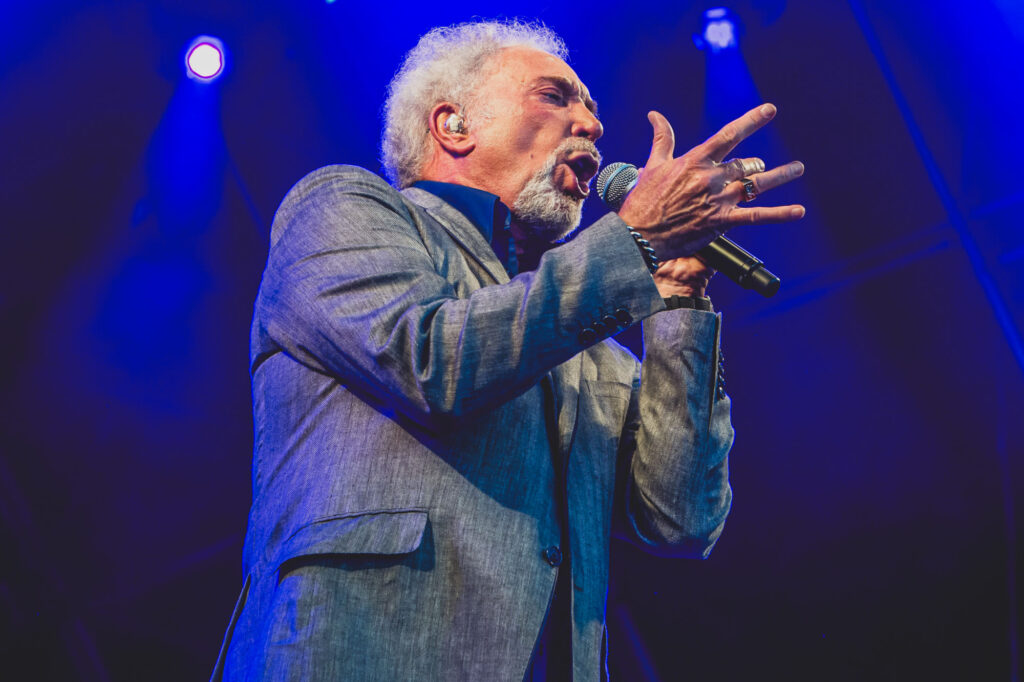 Tom Jones performs in concert and is on stage singing into a microphone - Freelance Press Photography from Blanc Creative Norwich