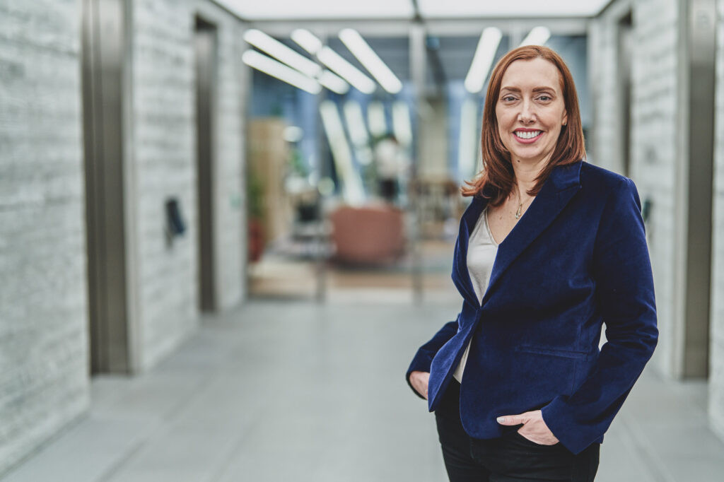 A professional female dressed in smart business clothing in a modern office in London