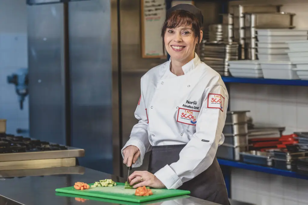 Female chef portrait, commercial kitchen environment, Norse Group uniform, preparing food — environmental portrait photography for facilities management businesses by Blanc Creative 