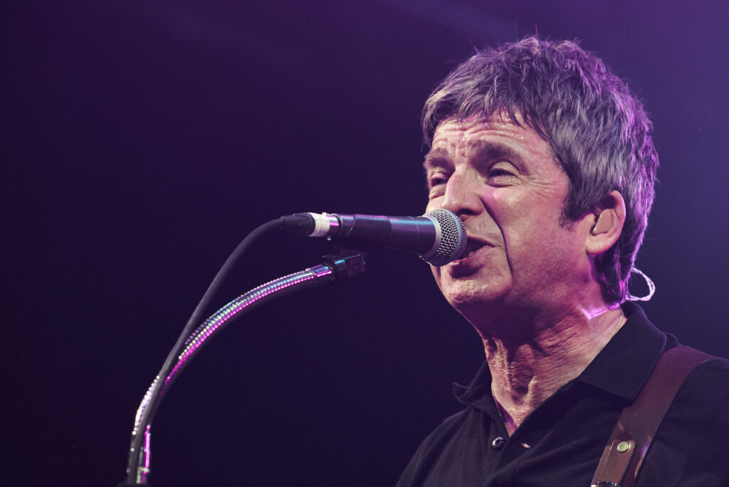 A close up image of Noel Gallagher singing on stage as the headline act at Sheffield Rock N Roll Circus 2023