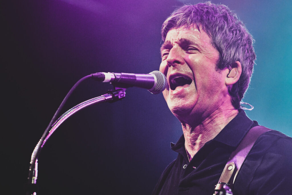 A close up image of Noel Gallagher singing on stage as the headline act at Sheffield Rock N Roll Circus 2023