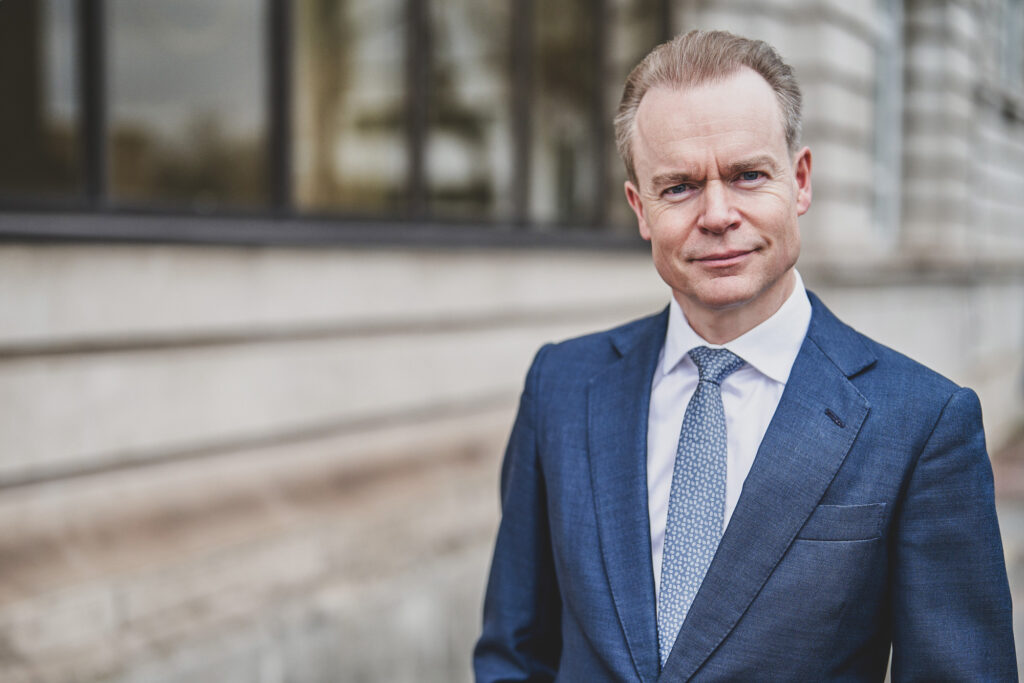 A portrait images of a Managing Director in a formal suit stands outside a London office looking towards the camera - Professional Business Portraits from Blanc Creative