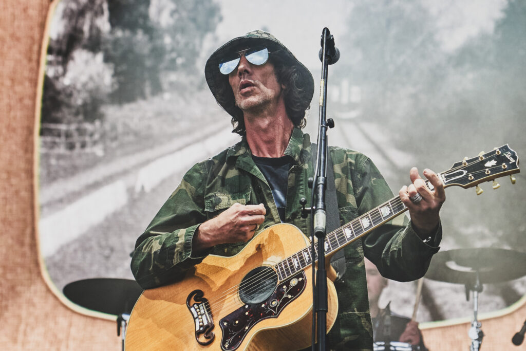 Richard Ashcroft performs and plays guitar on stage wearing a gucci bucket hat in 2023 - Professional Photography Blanc Creative