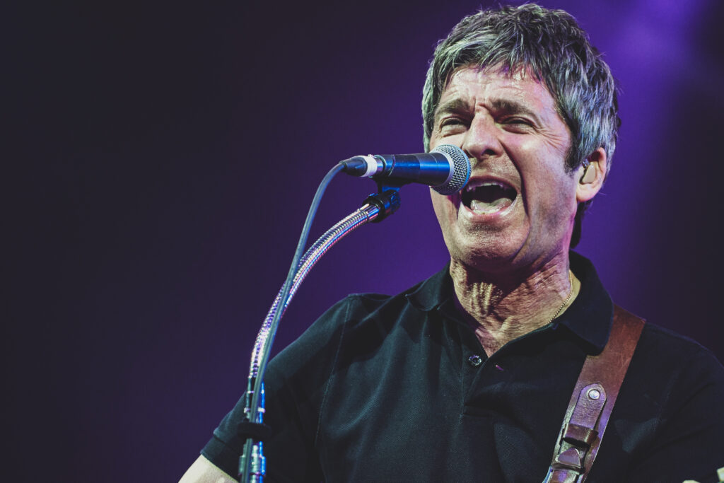 Noel Gallagher sings into a microphone while headlining at Sheffield Rock n Roll Circus - Music Photography by Lee Blanchflower of Blanc Creative