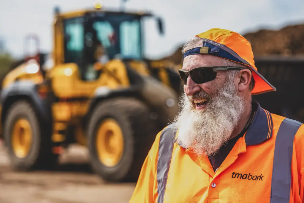 Male worker, orange hi-vis, moody natural light, industrial background — environmental portrait photography for trades and industry by Blanc Creative