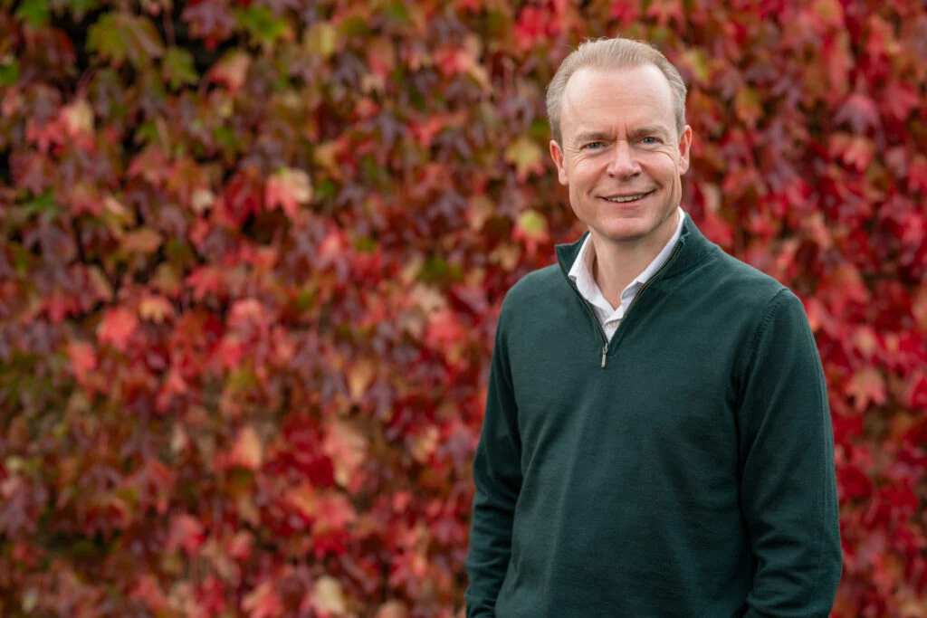 Blanc Creative Commercial Photography Norwich Male professional portrait, vibrant red autumn foliage background, natural light — environmental portrait photography Norwich by Blanc Creative