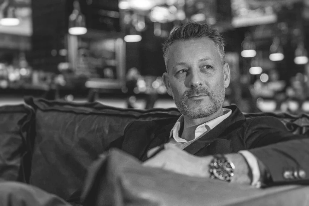 Male professional portrait, seated, warm toned interior — corporate portrait photography for professional services, Manchester