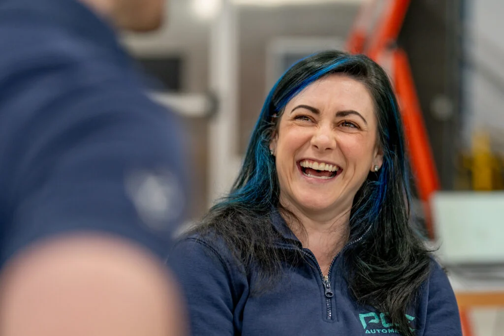 Blanc Creative Commercial Photography Norwich Female Operations Manager in industrial worklace laughing during a corporate headshot session at Adapt Engineering Dublin