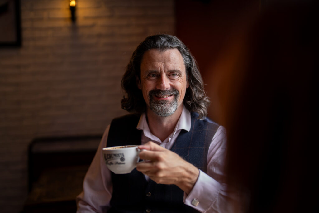 Dr Danny Kett of Rebelbridge Studio in conversation, natural light portrait in a Norwich café